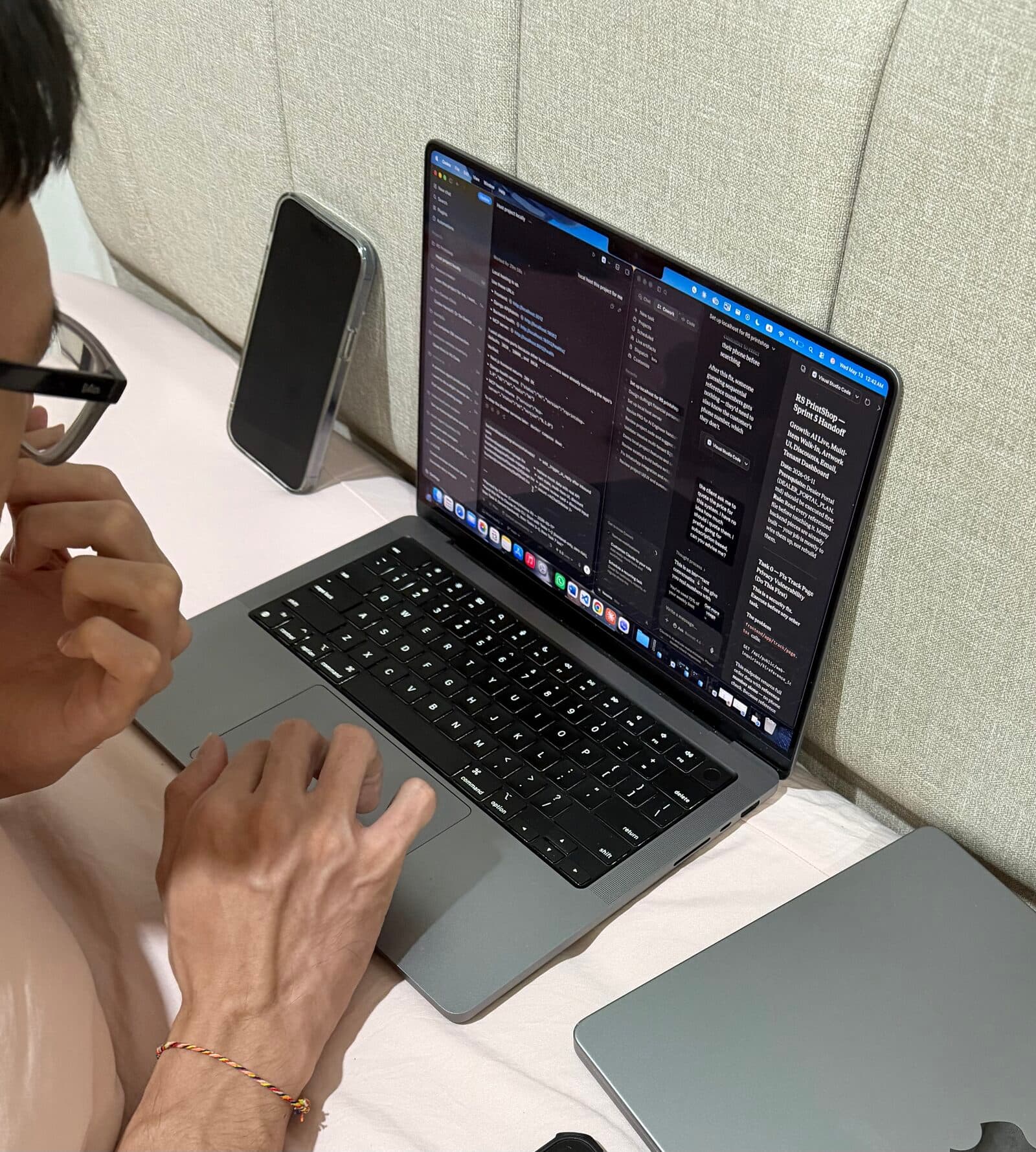 Working late at night, laptop open, phone propped beside it.